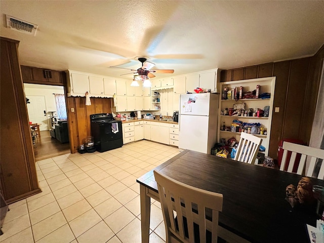 kitchen with white cabinetry, black electric range, a textured ceiling, light tile patterned floors, and white fridge