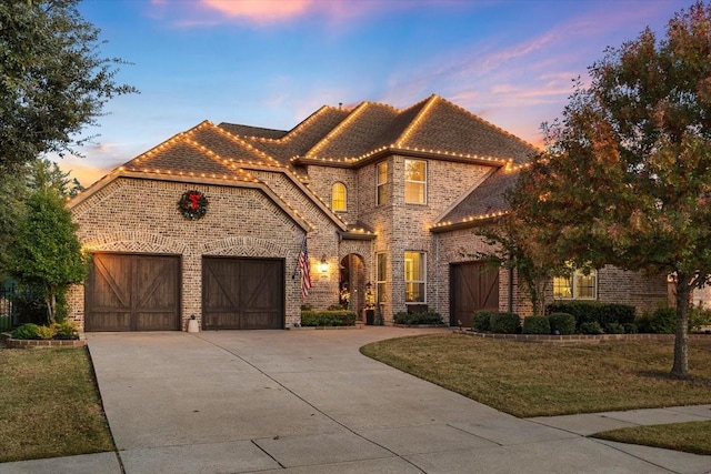 view of front of property with a garage and a yard