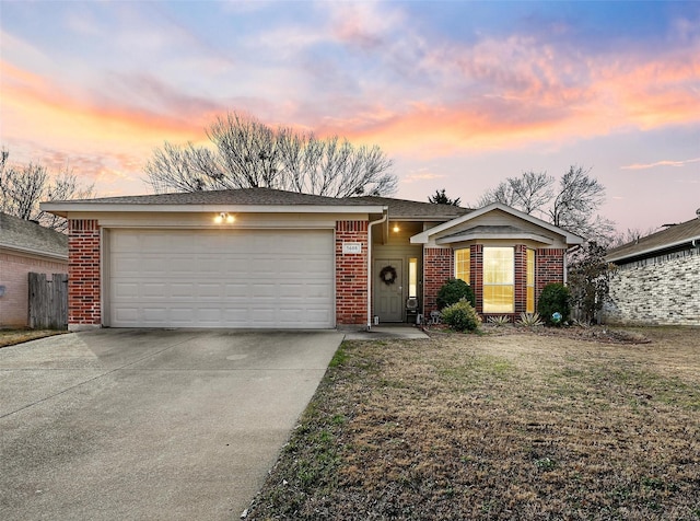 single story home featuring a garage and a yard