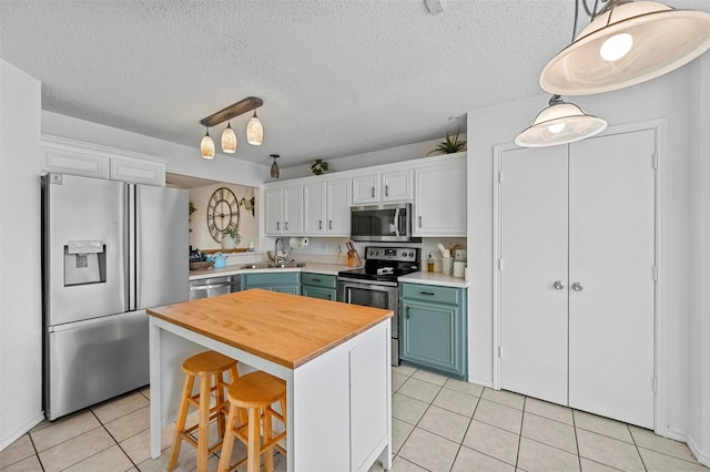 kitchen with sink, stainless steel appliances, a center island, and white cabinets