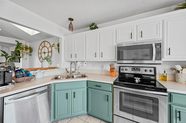 kitchen featuring light tile patterned flooring, white cabinetry, sink, stainless steel appliances, and a textured ceiling