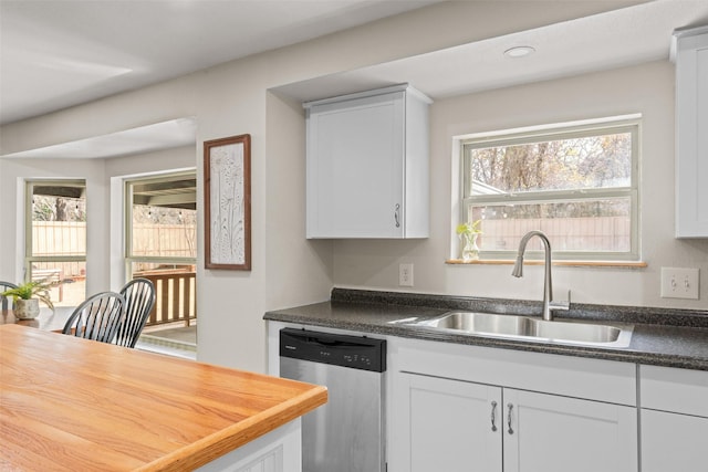 kitchen featuring white cabinetry, dishwasher, sink, and a wealth of natural light