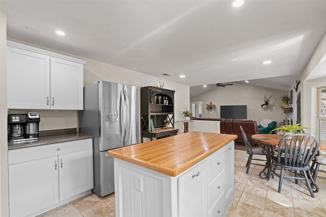 kitchen with stainless steel refrigerator with ice dispenser, lofted ceiling, white cabinetry, a kitchen island, and ceiling fan