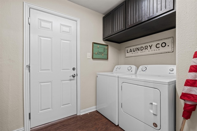 clothes washing area featuring cabinets, washer and dryer, and dark wood-type flooring