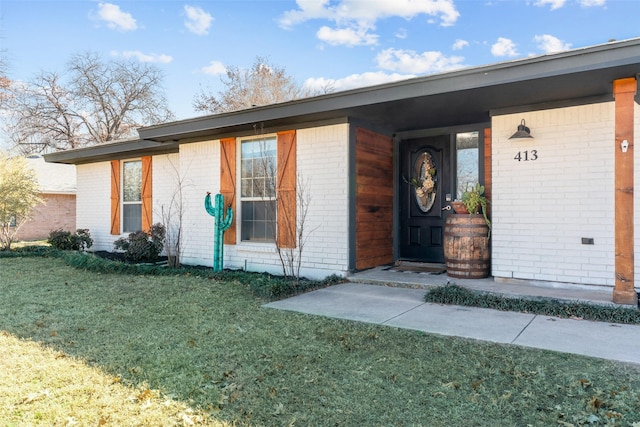 view of exterior entry featuring a yard