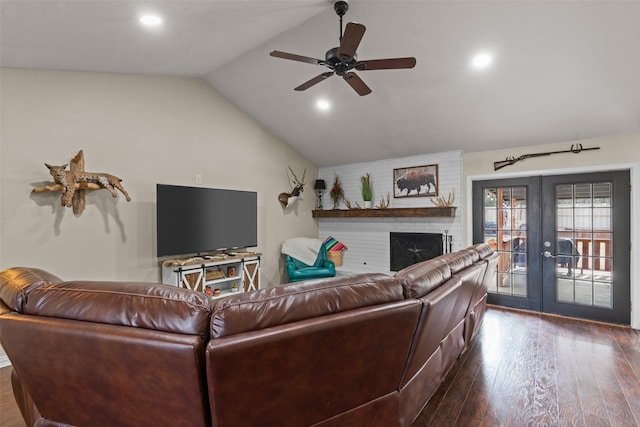 living room featuring a fireplace, lofted ceiling, ceiling fan, dark wood-type flooring, and french doors