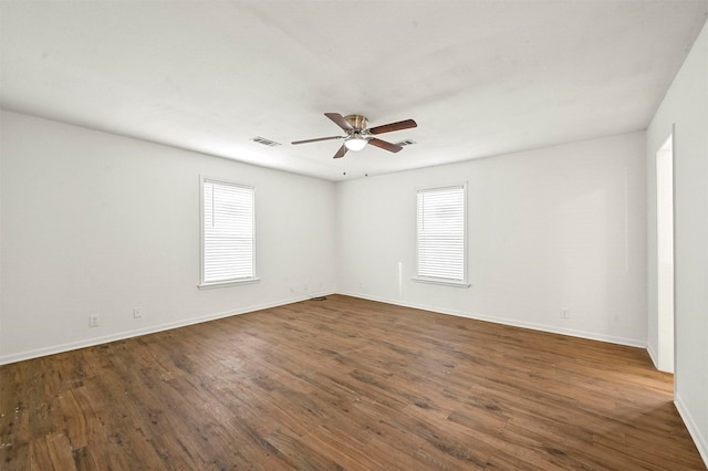 spare room with ceiling fan, plenty of natural light, and dark hardwood / wood-style flooring