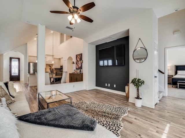 living room featuring ceiling fan, high vaulted ceiling, and light hardwood / wood-style floors