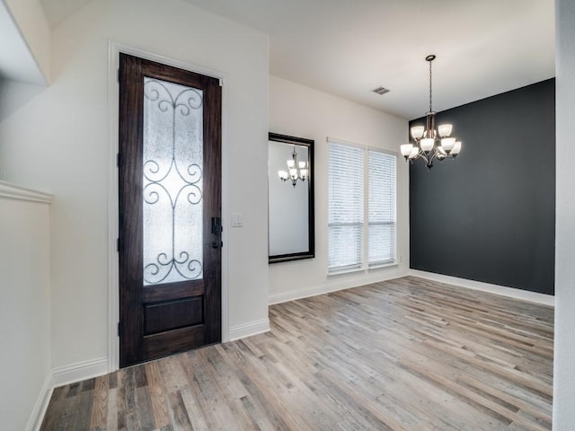 foyer entrance featuring an inviting chandelier and light wood-type flooring