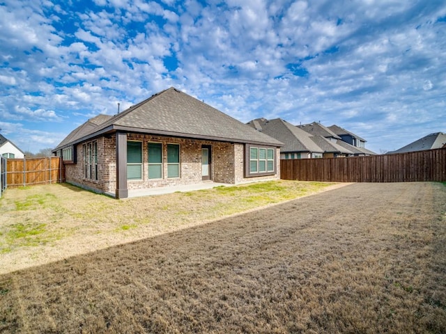 rear view of house with a yard and a patio