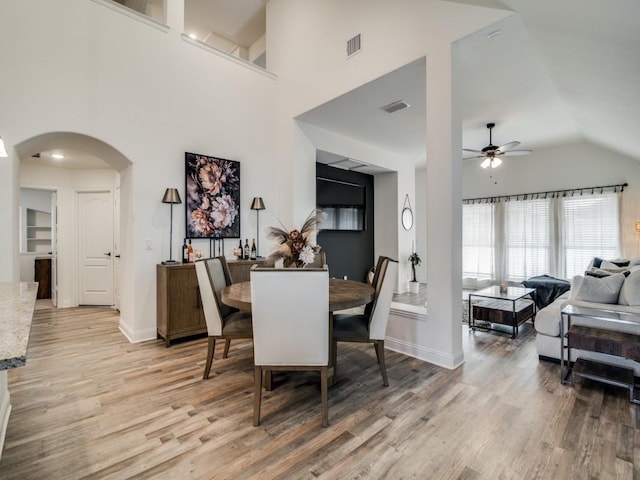 dining area featuring vaulted ceiling, light hardwood / wood-style floors, and ceiling fan