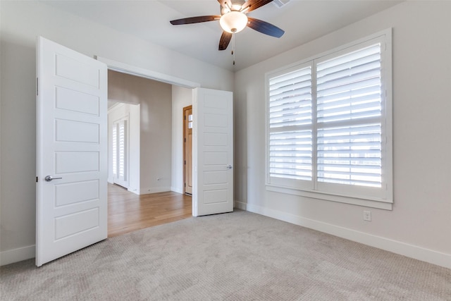 carpeted spare room featuring ceiling fan