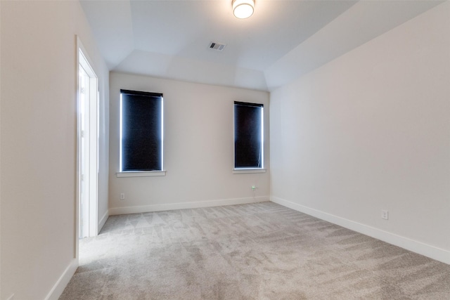 unfurnished room with lofted ceiling and light colored carpet