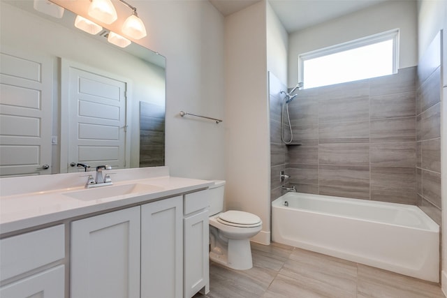 full bathroom with tiled shower / bath, vanity, and toilet