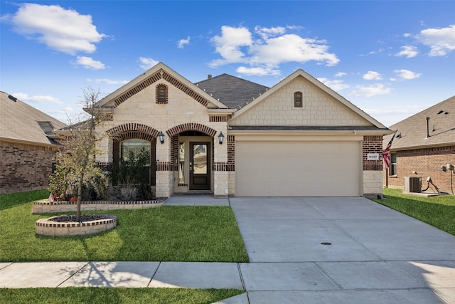 view of front of home with a garage, central AC, and a front lawn