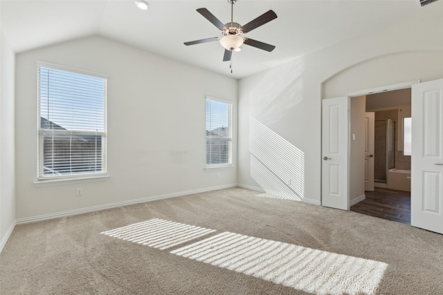 spare room featuring lofted ceiling, light carpet, and ceiling fan