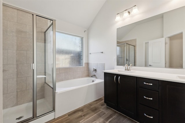 bathroom featuring lofted ceiling, independent shower and bath, and vanity