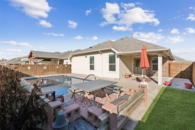 rear view of house with a fenced in pool and a patio