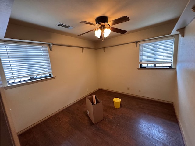 empty room with dark wood-type flooring and ceiling fan