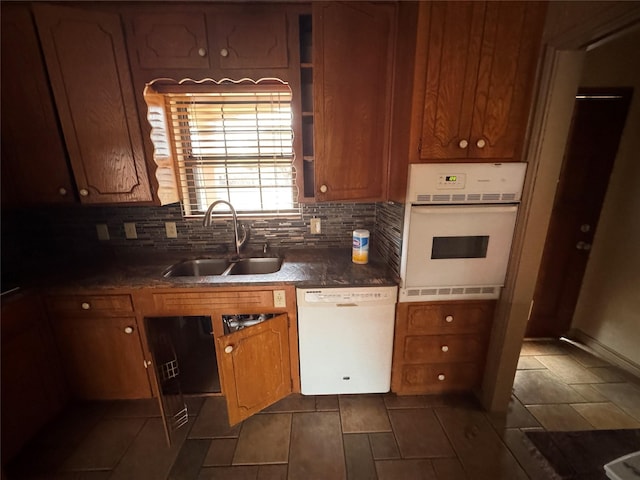 kitchen with white appliances, sink, and backsplash