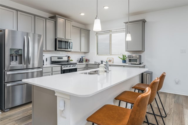 kitchen featuring a sink, gray cabinetry, tasteful backsplash, and stainless steel appliances