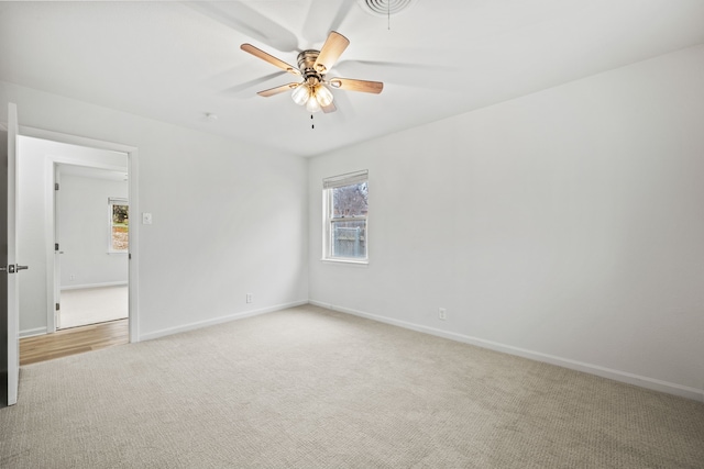 carpeted spare room featuring ceiling fan