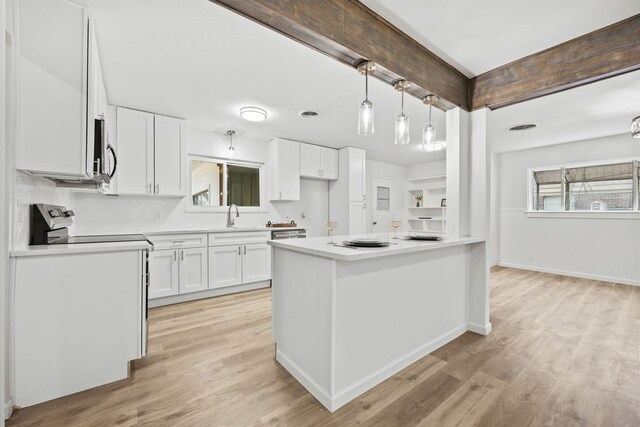 kitchen featuring sink, tasteful backsplash, hanging light fixtures, light hardwood / wood-style floors, and white cabinets