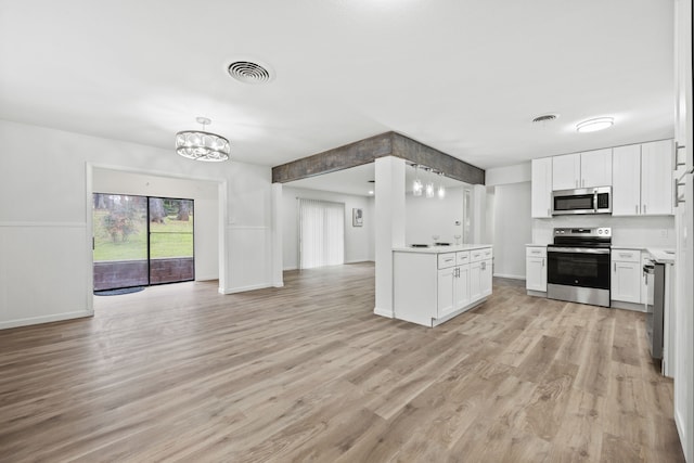 kitchen with stainless steel appliances, white cabinetry, and light wood-type flooring