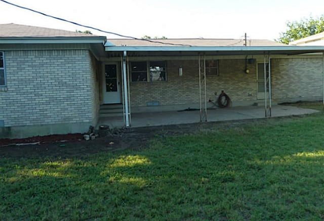 entrance to property featuring a yard and a patio area