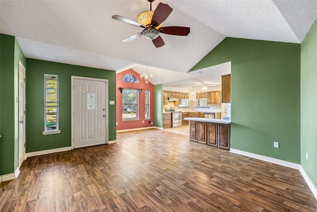 unfurnished living room with dark wood-type flooring, a healthy amount of sunlight, and lofted ceiling