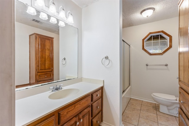 full bathroom featuring tile patterned floors, toilet, combined bath / shower with glass door, a textured ceiling, and vanity