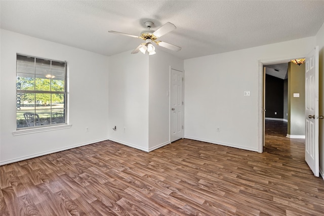 empty room featuring ceiling fan, hardwood / wood-style floors, and a textured ceiling