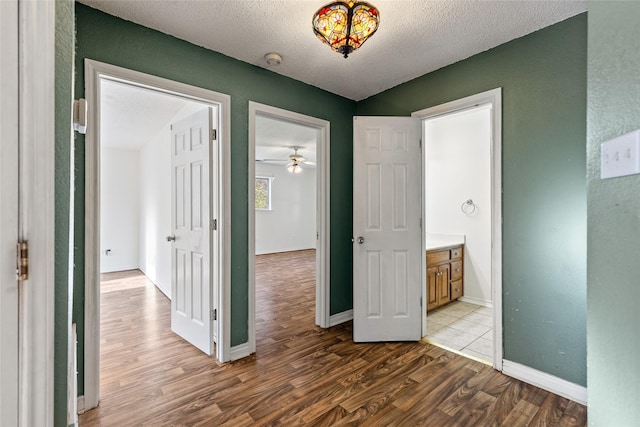 unfurnished bedroom featuring connected bathroom, hardwood / wood-style floors, and a textured ceiling