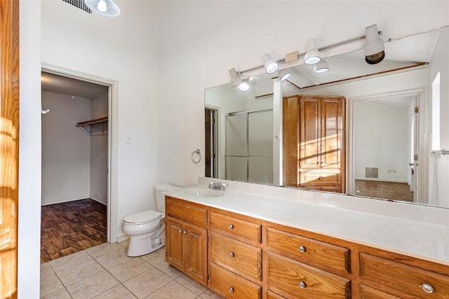 bathroom featuring vanity, tile patterned floors, toilet, and walk in shower