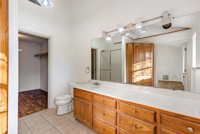 bathroom featuring vanity, tile patterned floors, toilet, and walk in shower