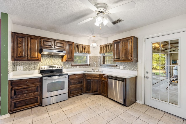 kitchen featuring sink, plenty of natural light, stainless steel appliances, and hanging light fixtures