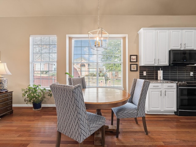 dining space with dark wood-type flooring and a chandelier