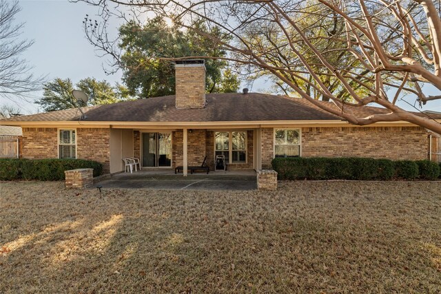 rear view of property featuring a yard and a patio area