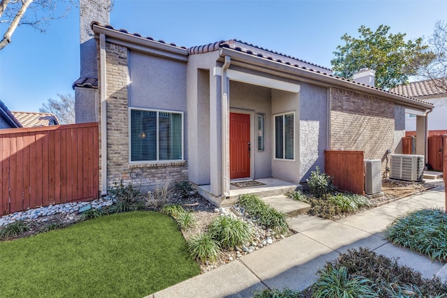 view of front of property with central AC and a front lawn