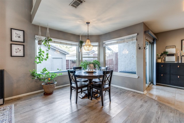 dining space featuring hardwood / wood-style floors and a notable chandelier