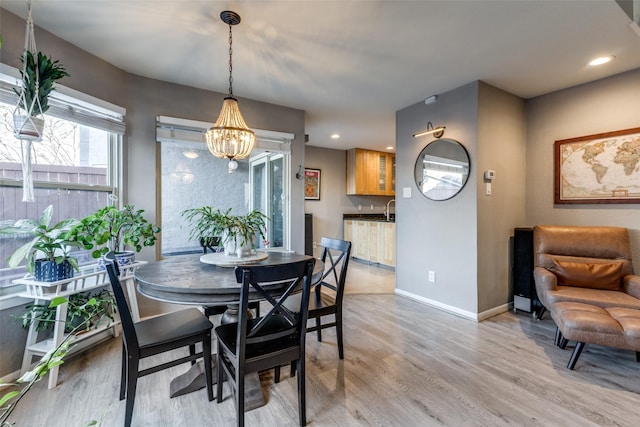 dining space featuring a notable chandelier and light hardwood / wood-style flooring