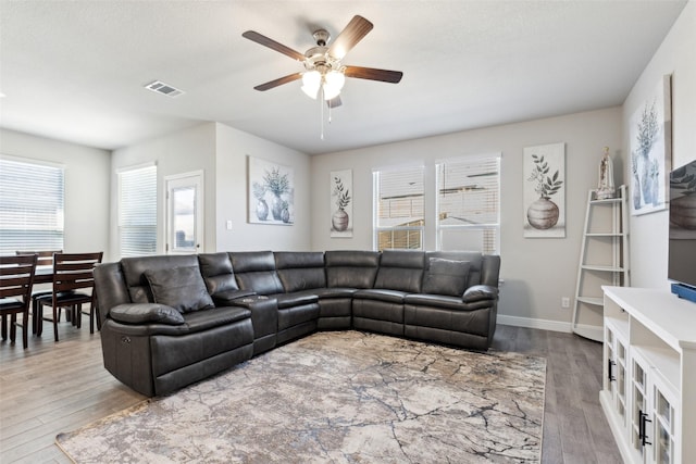 living room with hardwood / wood-style flooring, a textured ceiling, and ceiling fan