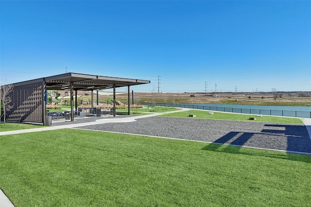 surrounding community with a lawn and a water view