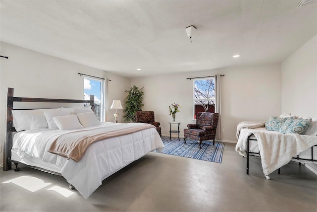 bedroom featuring multiple windows and concrete floors