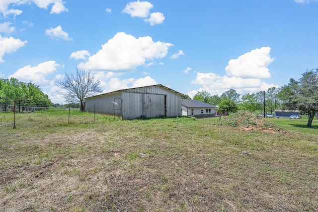 view of outbuilding with a rural view and a lawn