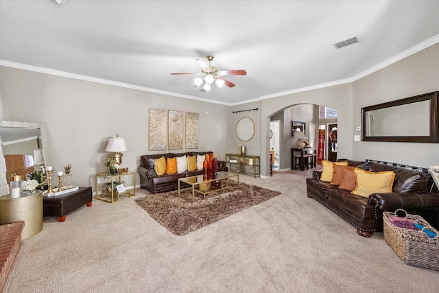 carpeted living room with crown molding and ceiling fan