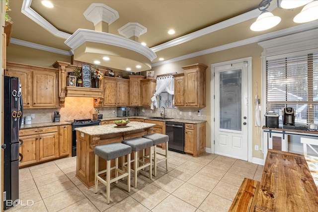 kitchen with sink, a center island, a tray ceiling, ornamental molding, and black appliances