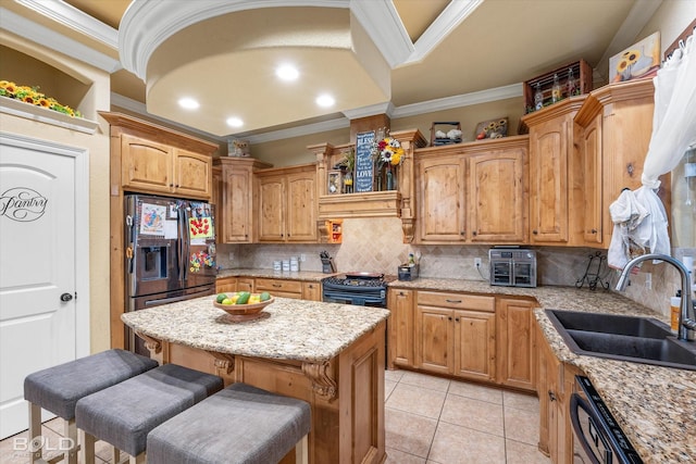 kitchen featuring sink, backsplash, a kitchen bar, ornamental molding, and a kitchen island