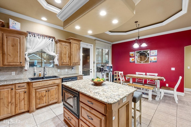 kitchen featuring sink, crown molding, black microwave, a tray ceiling, and a kitchen island