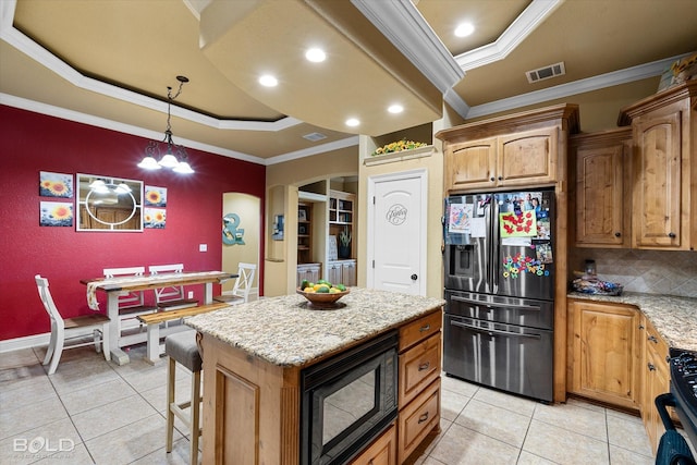 kitchen featuring a kitchen island, black microwave, stainless steel fridge, ornamental molding, and a raised ceiling